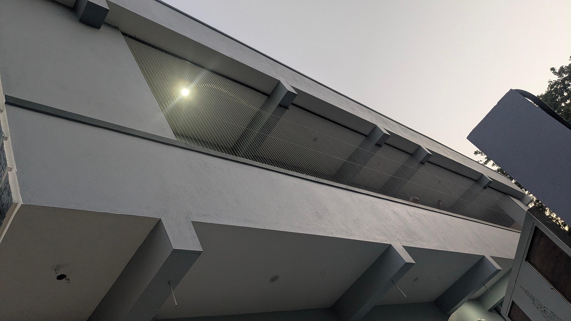 House balcony seen from below – invisible grill installation by HomeNest Invisible Grills
